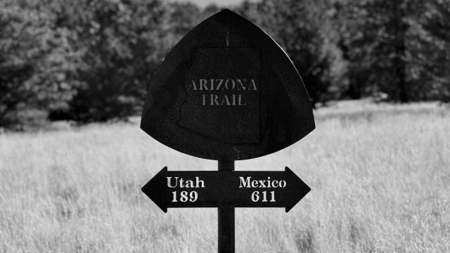 A metal signs points to the souther and northern ends of the Arizona Trail