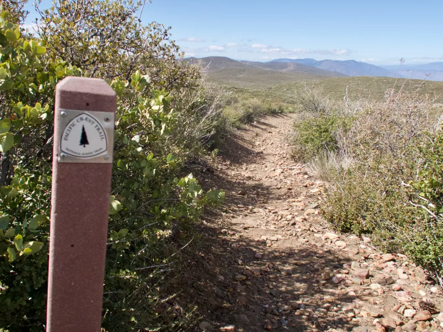 Rocky trail with trail marker on post