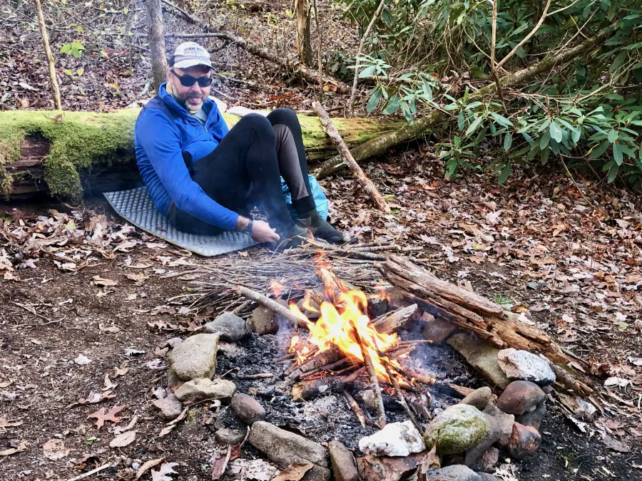 Just Awesome sits by the fire he built