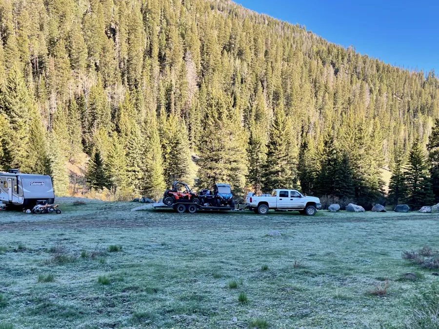 A camper and ATVs are parked near Park Creek