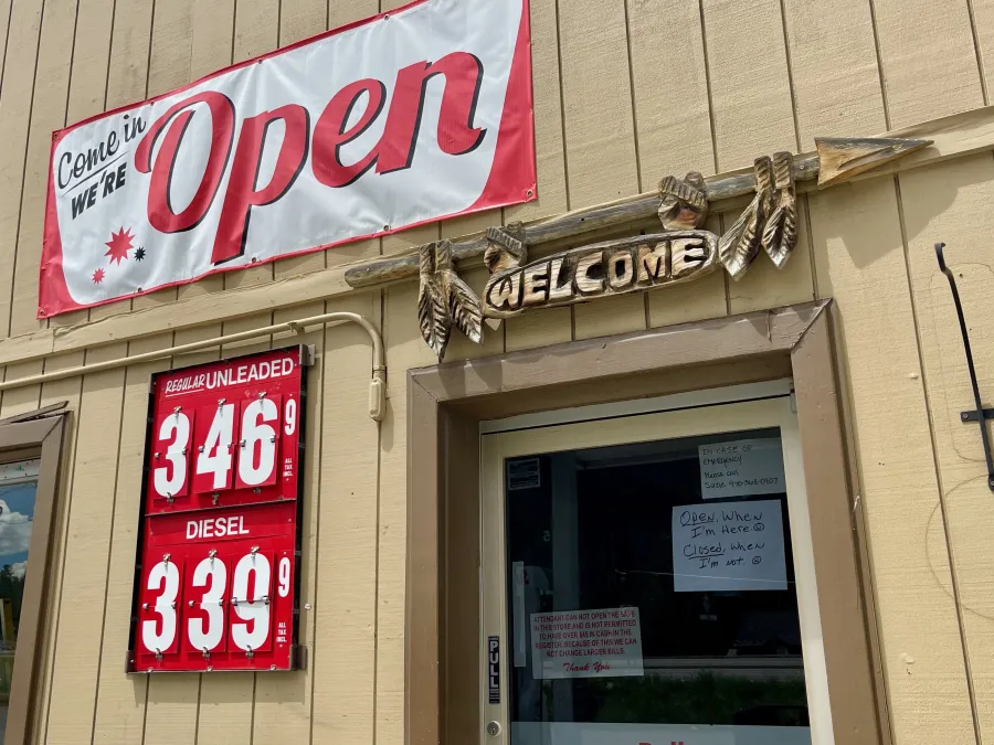 A sign says the gas station is open