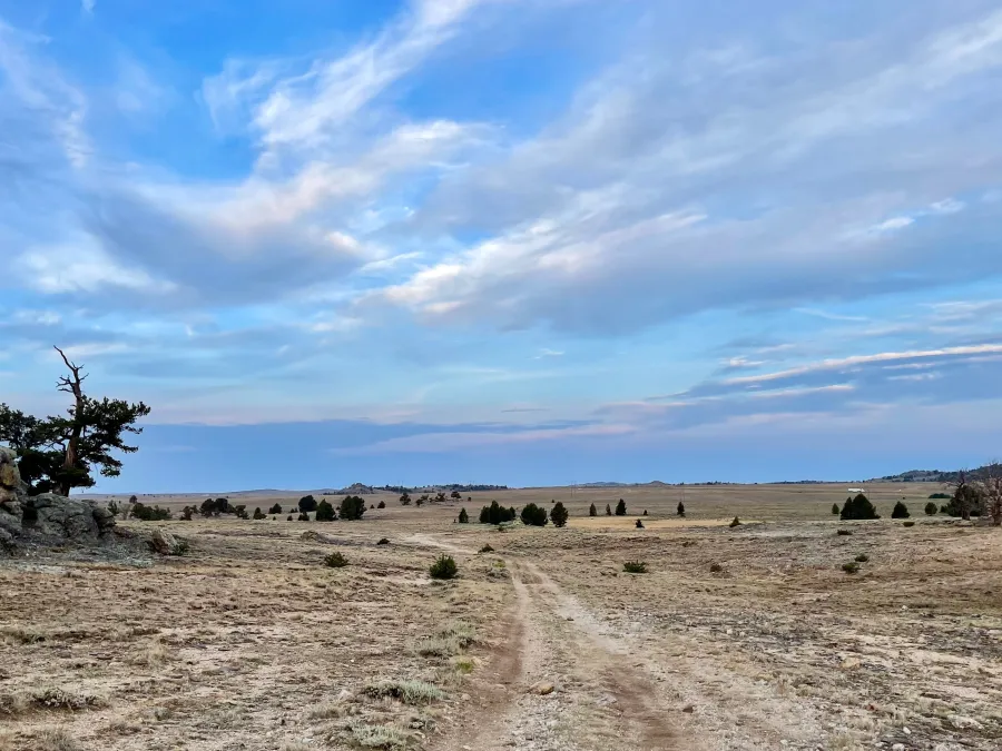 A wide view of the trail and a mostly-cloudy sky
