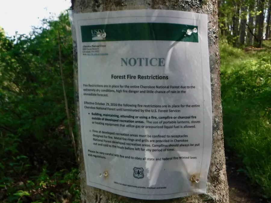 A fire warning sign posted near the trail