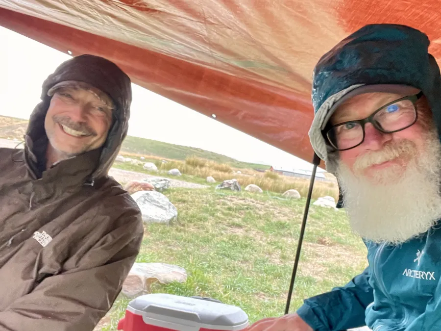 Polecat and Gravity sit under a tarp