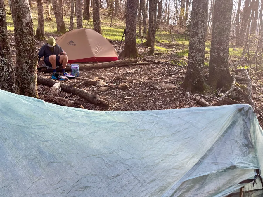 Polecat sits outside his tent