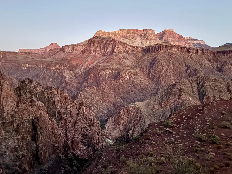 The day's first sunlight begins to appear over the canyon