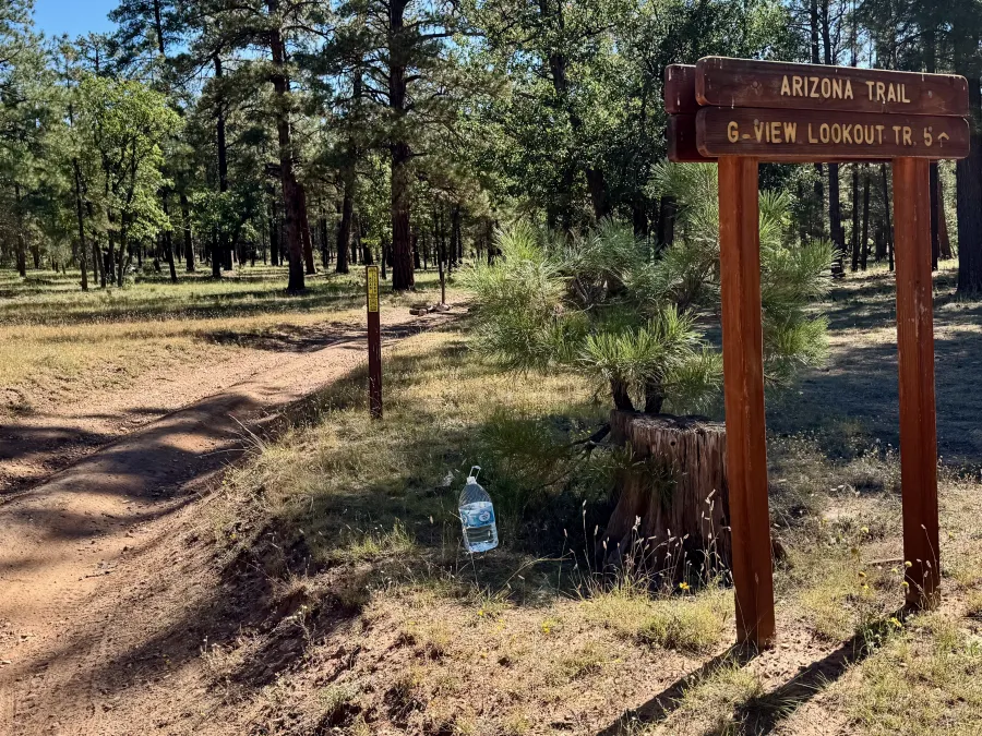 A water jug sits at a trail junction