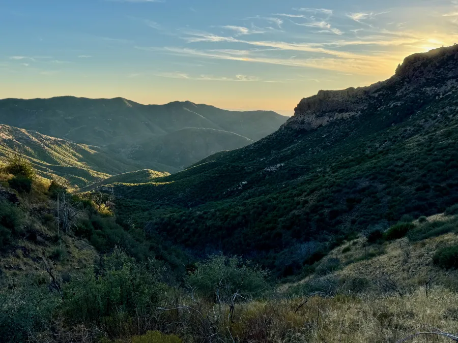 The sun sinks behind a mountain