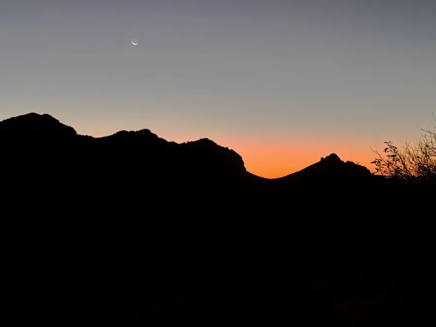 A crescent moon appears at dawn