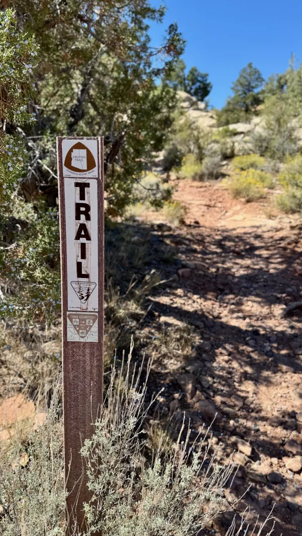A trail marker with an AZT logo