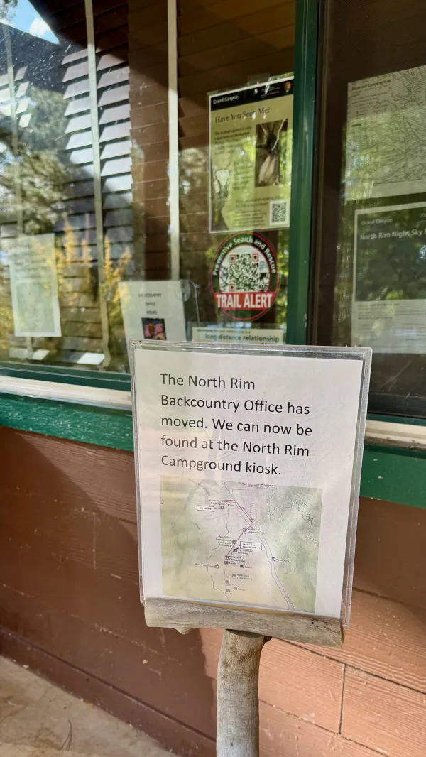 A sign says the backcountry office has moved