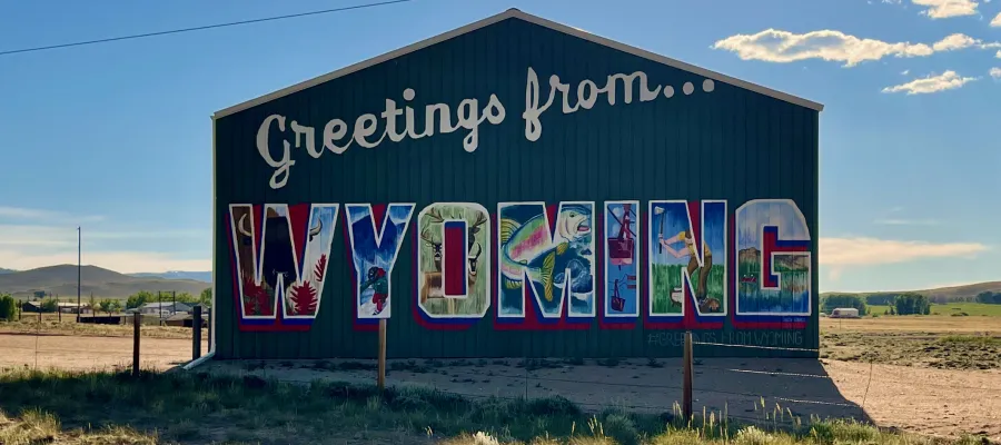A barn is painted to say Greetings from Wyoming