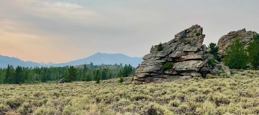 Large rocks stand against a smokey sky