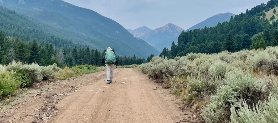 Top O' walks on a road toward mountains