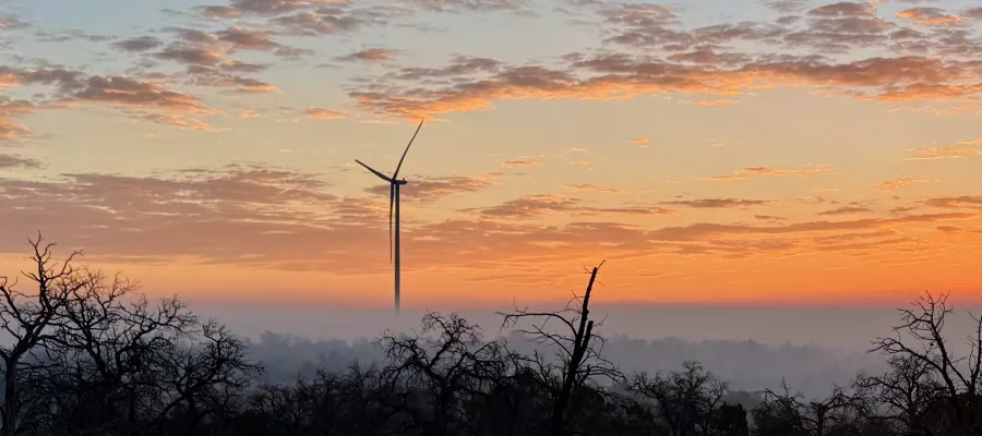 A view of a windmill at sunrise