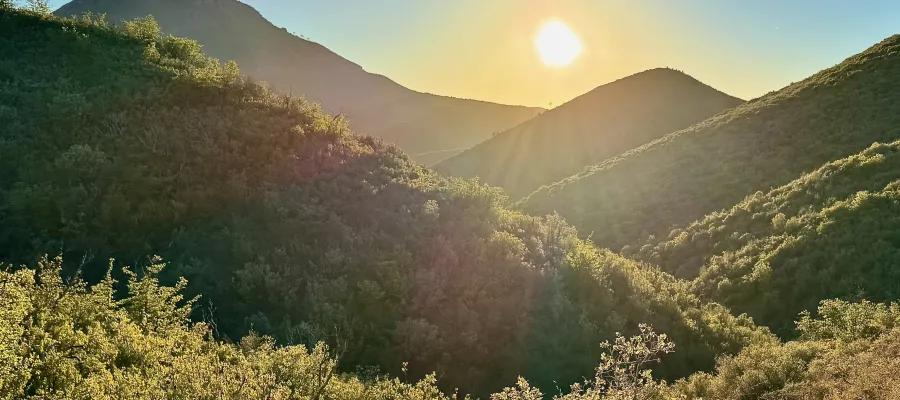Sun setting over a mountain ridge