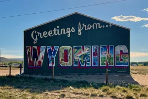A barn is painted to say Greetings from Wyoming