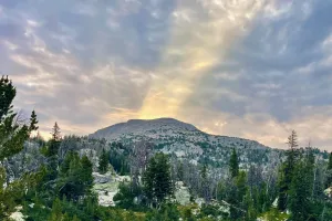 Rays of morning sun shine over a ridge