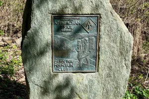 A bronze plaque mounted to a large boulder on the AT