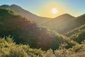 Sun setting over a mountain ridge
