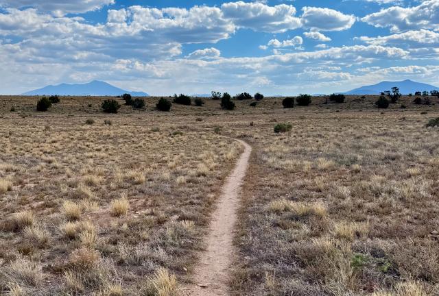 The trail crosses flat desert