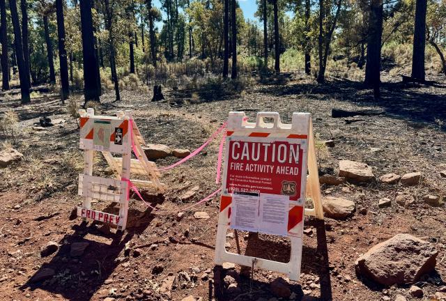 A barricade and sign warning of a burn area and detour ahead